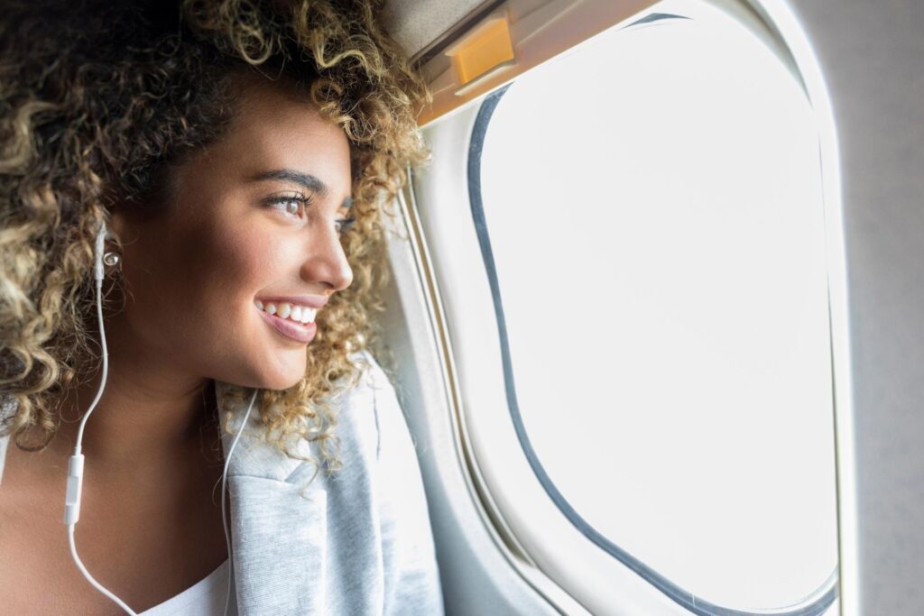 Kvinde sidder i fly og kigger ud ad vinduet